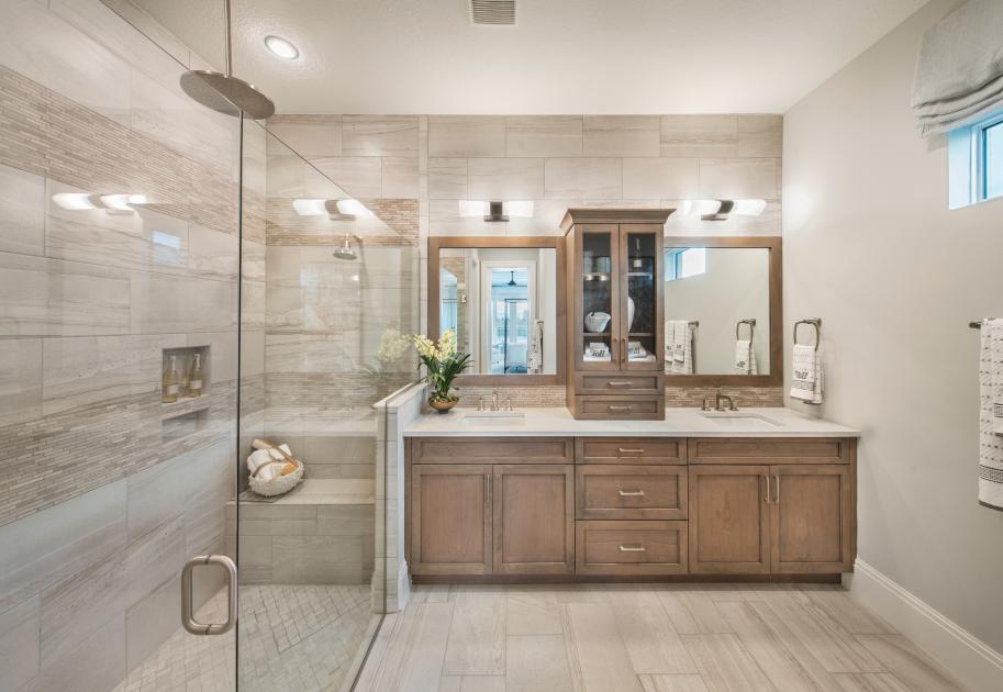 Luxurious primary bath with glass-enclosed shower and dual vanities