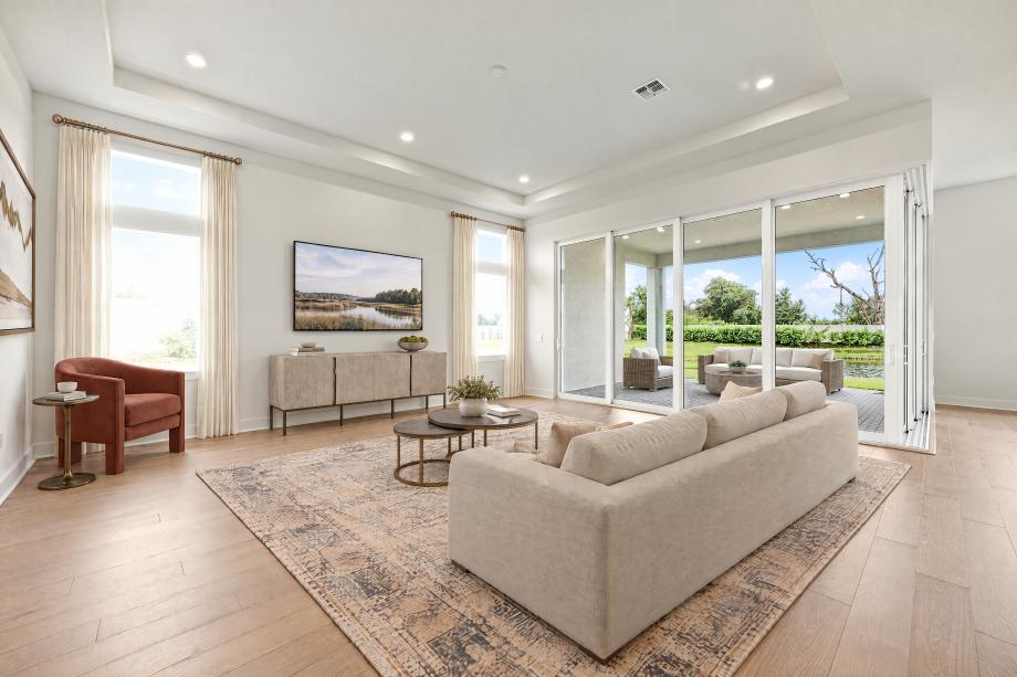 Expansive great room with tray ceiling and sliding glass doors to the covered lanai