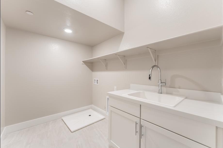 Spacious laundry with cabinets and sink