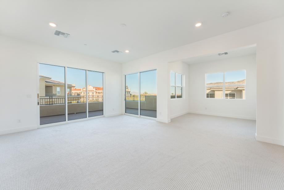 Generous primary bedroom suite with dual sliders to veranda