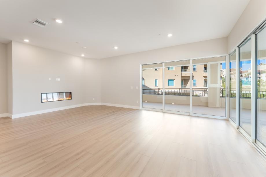 Large open great room with corner sliders and linear fireplace