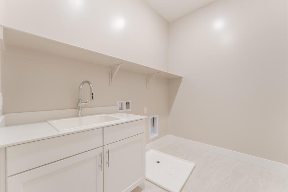 Spacious laundry with cabinets and sink