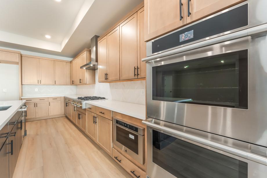 Upgraded hard surface with herringbone pattern tile backsplash