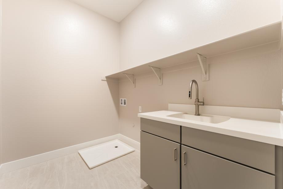 Spacious laundry with cabinets and sink