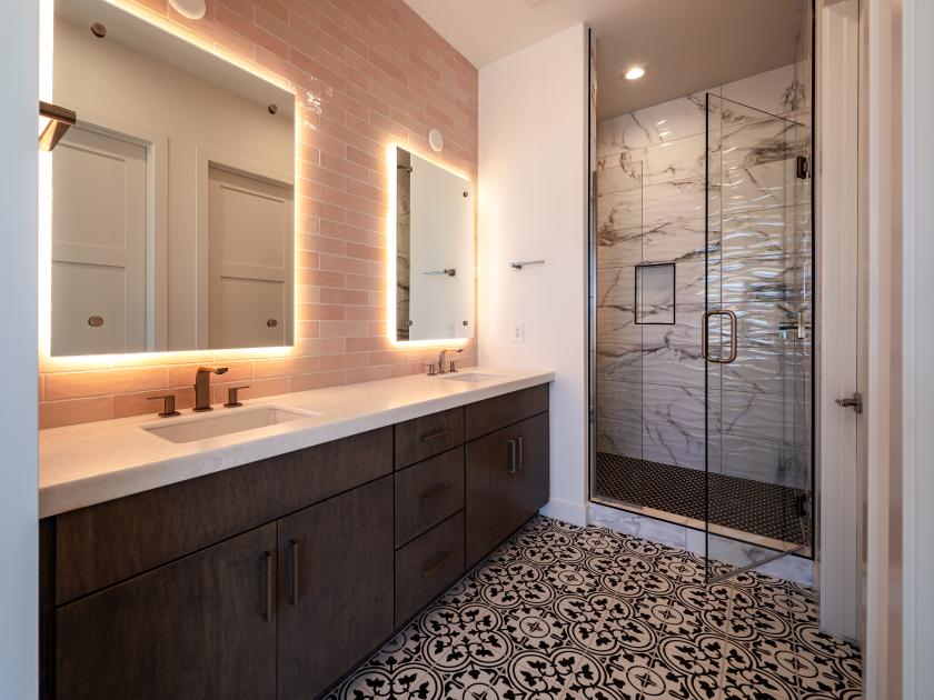 Bathroom with backlit mirrors and stunning shower tile