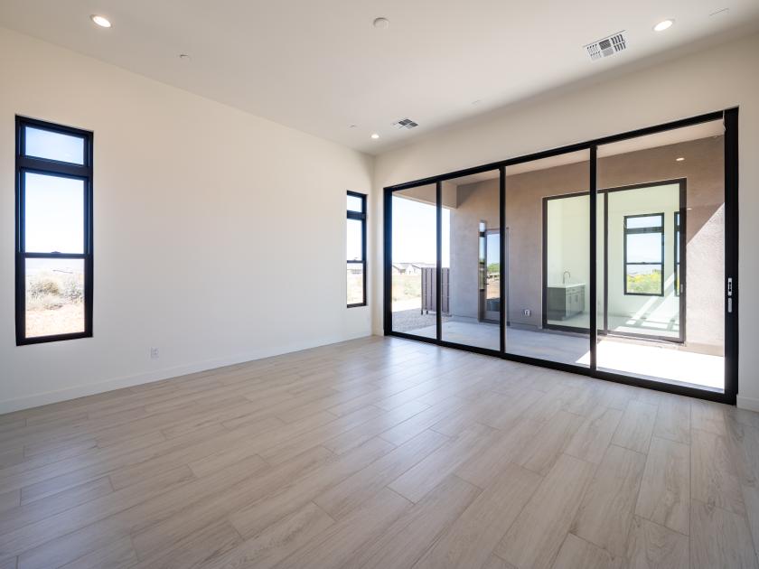 Primary bedroom suite with stunning fixtures, sliding glass door, and an abundance of natural light