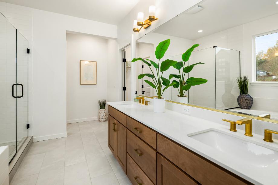 Primary bathroom offers a dual-sink vanity, walk-in shower, and soaking tub