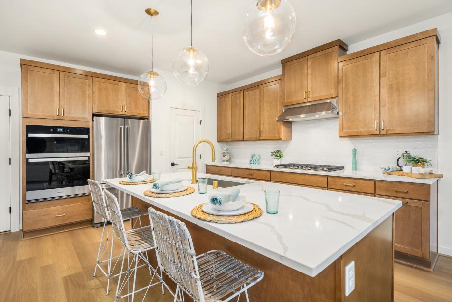 Quartz countertops beautifully accent the warm toffee stained cabinets