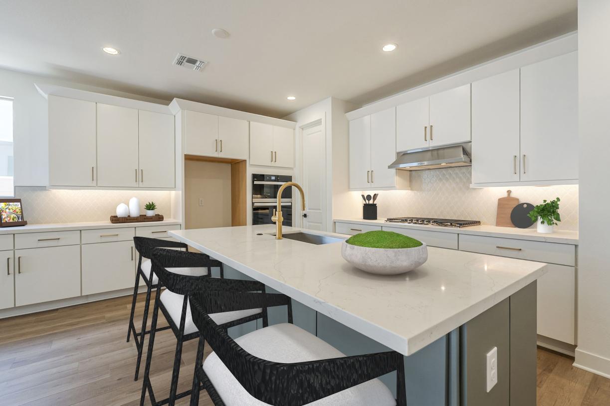 Beautiful kitchen with upgraded cabinets, striking tile backsplash, and spacious island