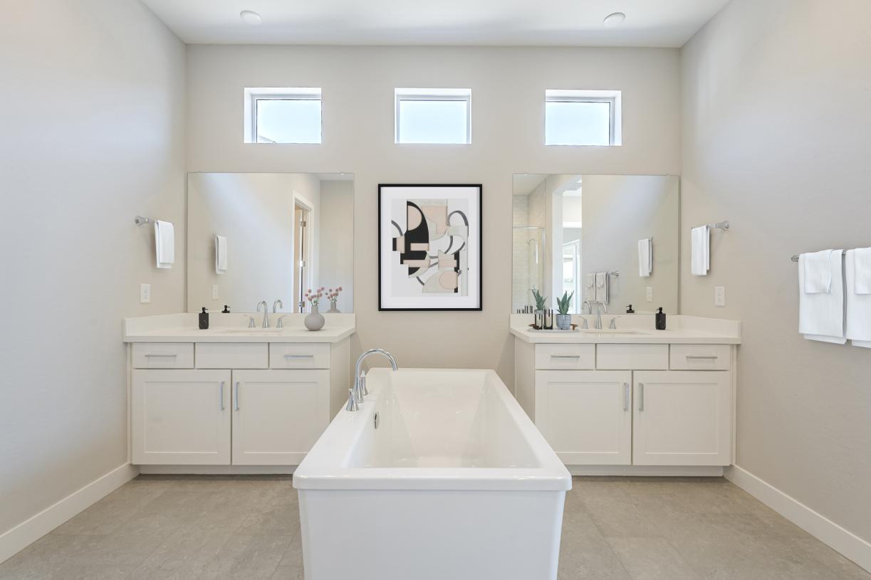 Gorgeous primary bathroom with dual vanities, glass shower door, and standalone tub