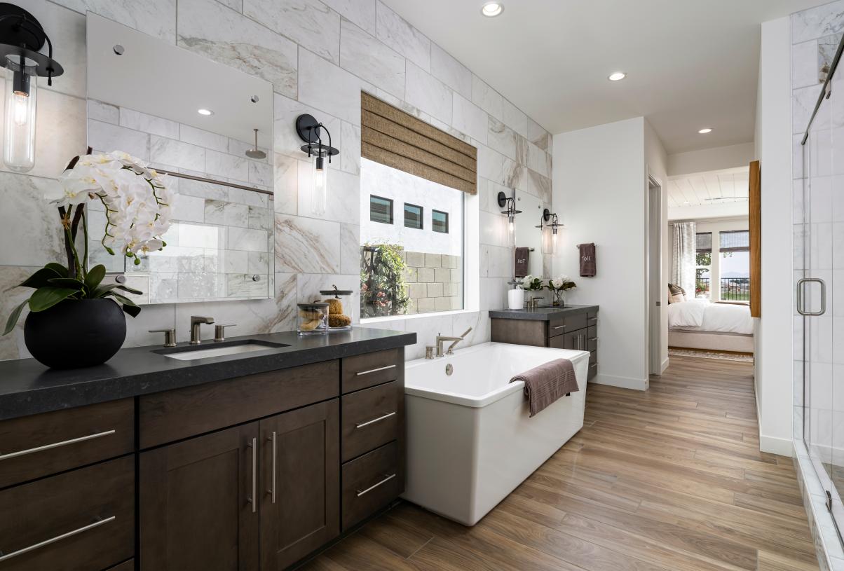 Gorgeous primary bathroom with dual vanities, glass shower door, and standalone soaking tub