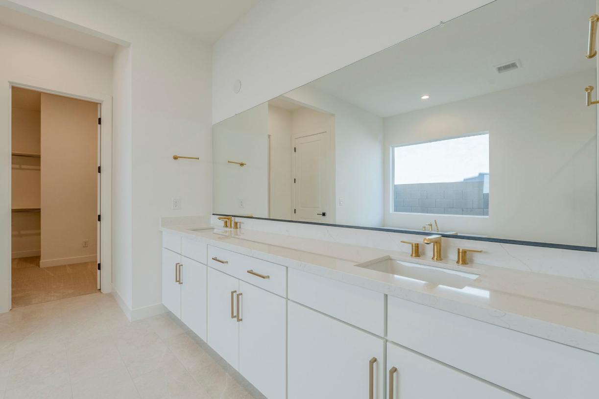 Serene primary bathroom with glass shower door, standalone soaking tub, and dual-sink vanity