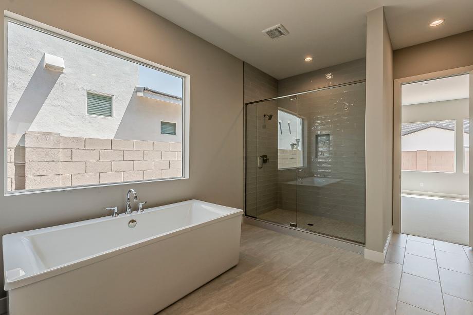 Primary bathroom with glass shower door and standalone soaking tub