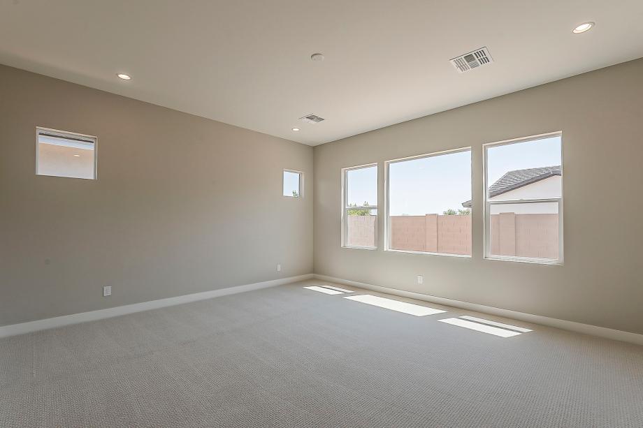 Expansive primary bedroom with luxurious neutral finishes