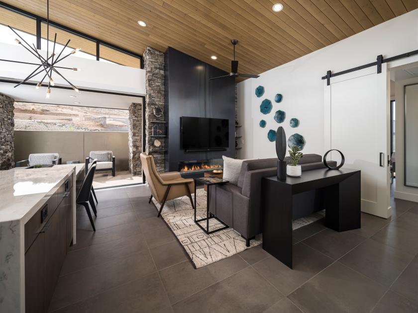 Open great room with fireplace, vaulted ceilings, and 90-degree multi-slide door