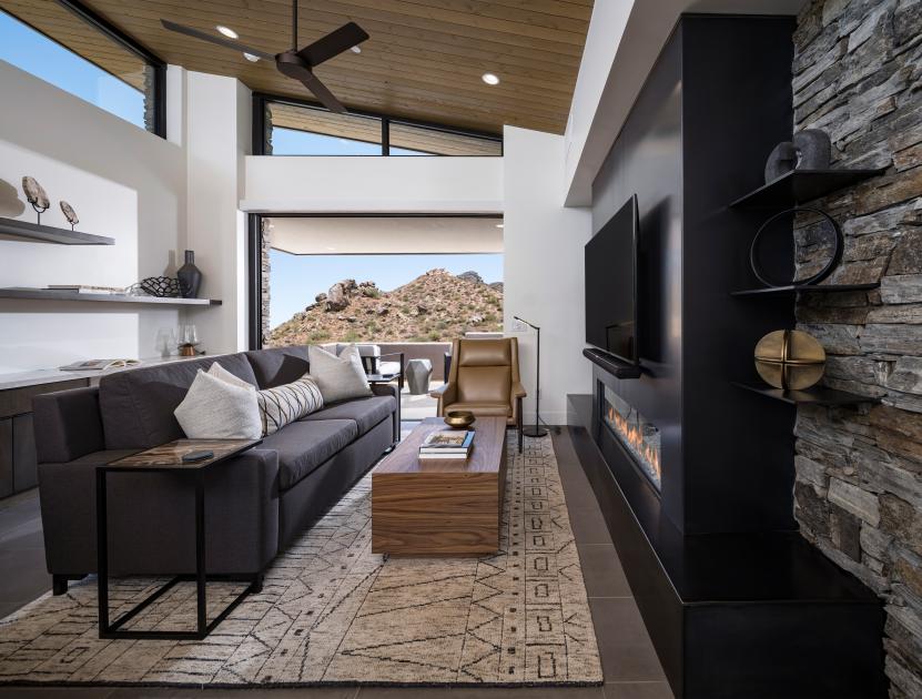 Open great room with fireplace, vaulted ceilings, and multi-slide patio door