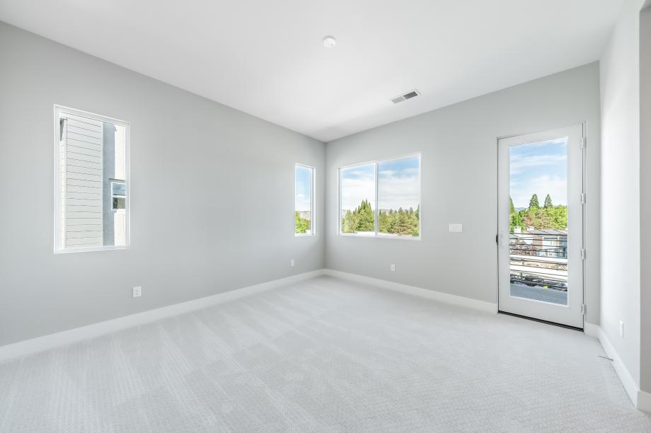 Spacious primary bedroom suites with ample natural light and a seating area for relaxation