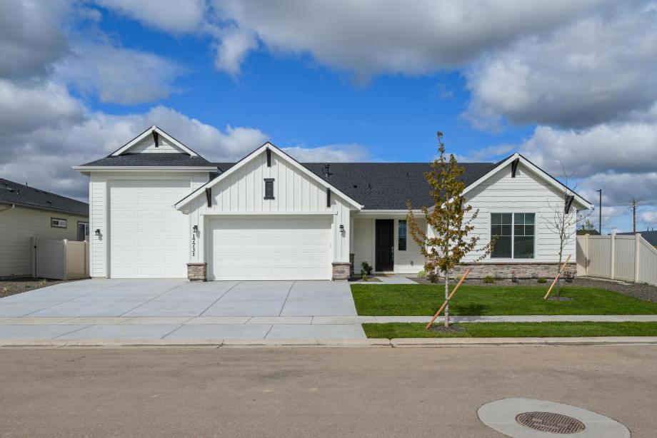 The open front porch and three-car garage provide both functionality and charm