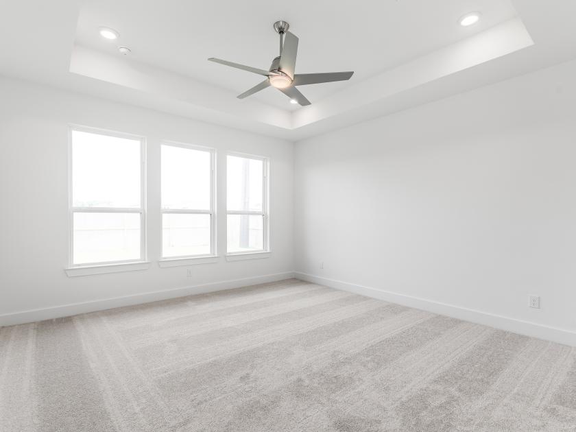 First-floor primary bedroom suite with tray ceilings