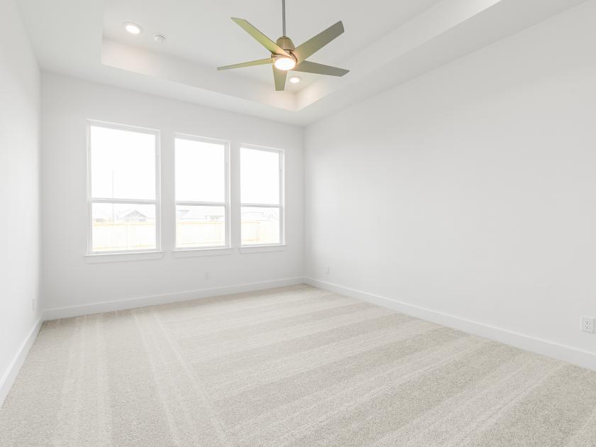 Large primary bedroom suite with ample natural light and a seating area