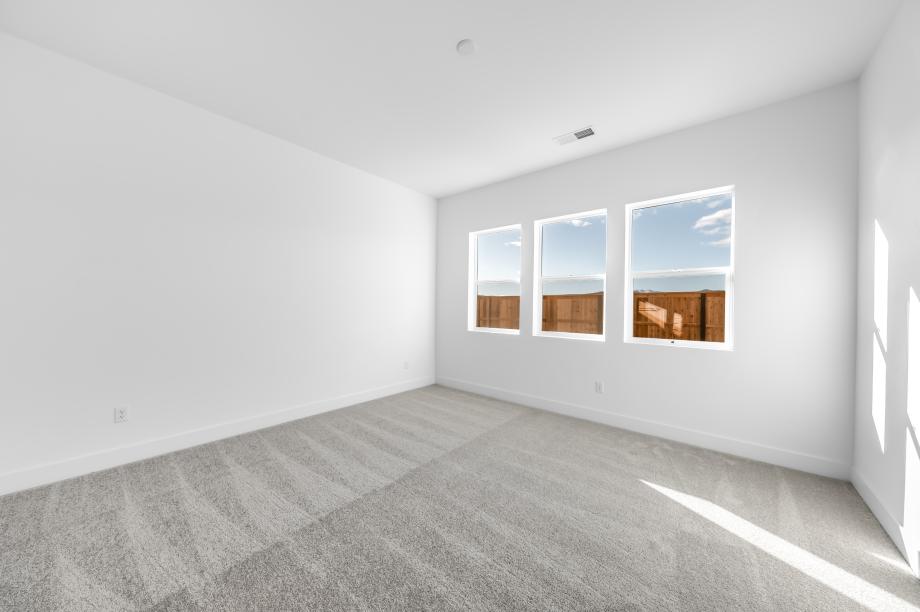 Large primary bedroom suite with ample natural light and a seating area