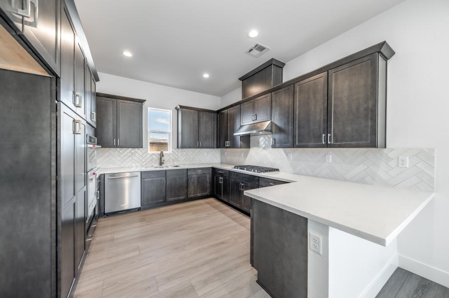 Well-equipped kitchen with stunning cabinets and tile backsplash