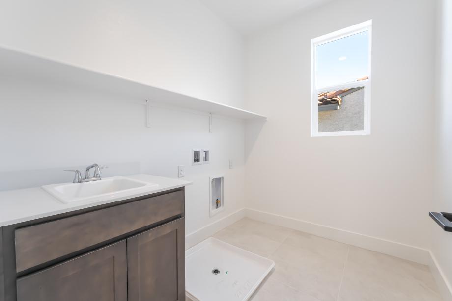 Large laundry with cabinets and sink