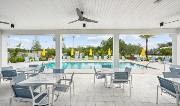 Covered outdoor lounge overlooking the sparkling pool, perfect for relaxing or connecting with neighbors at Retreat at Town Center