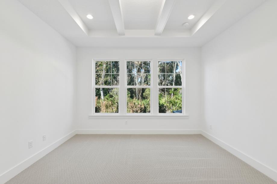 Large first-floor primary bedroom suite with ample natural light and a seating area