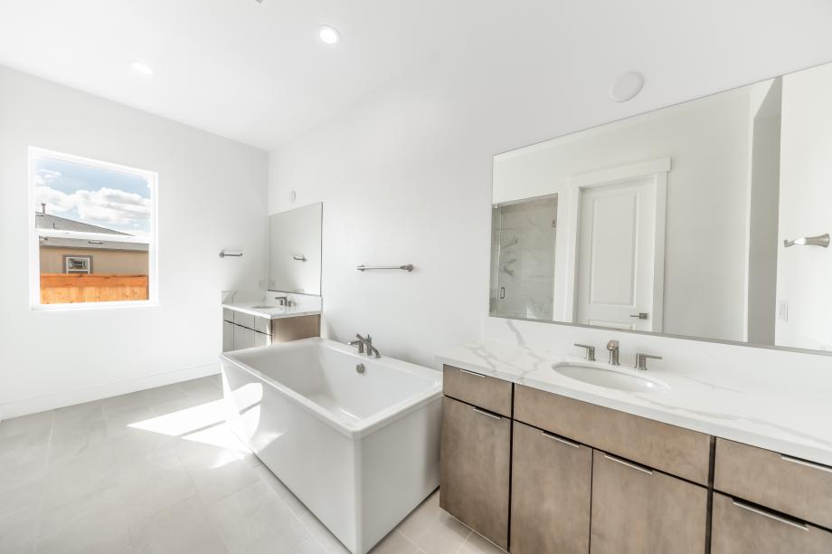 Lavish primary bathroom with a large walk-in shower and freestanding soaking tub