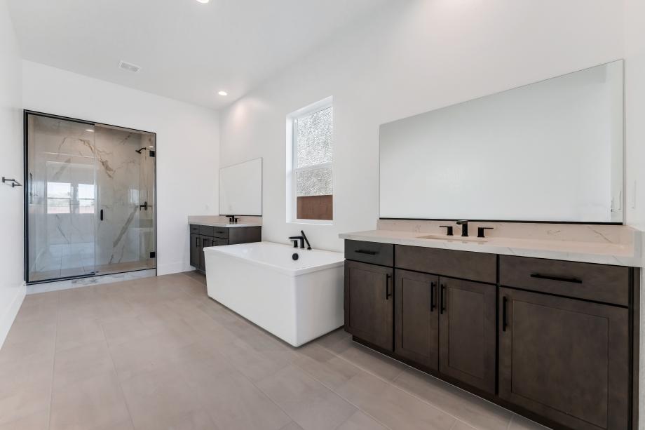 Beautiful primary bath with separate dual vanities and large soaking tub