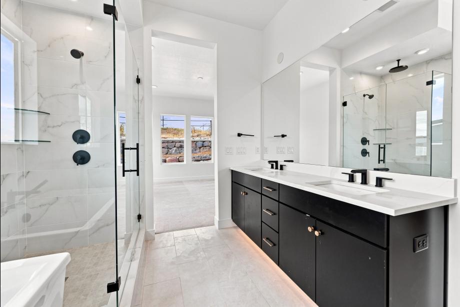 Spa-like primary bathroom with dual sink vanities, walk-in shower and freestanding tub