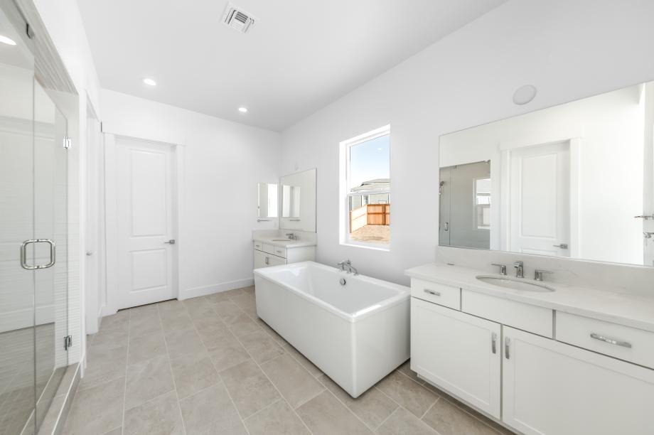 Spa-like primary bathroom with a large walk-in shower and freestanding soaking tub