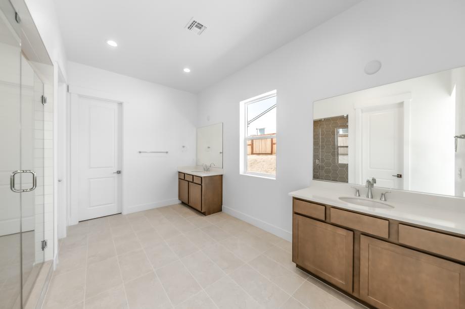 Spa-like primary bathroom with a large walk-in shower and dual-sink vanity