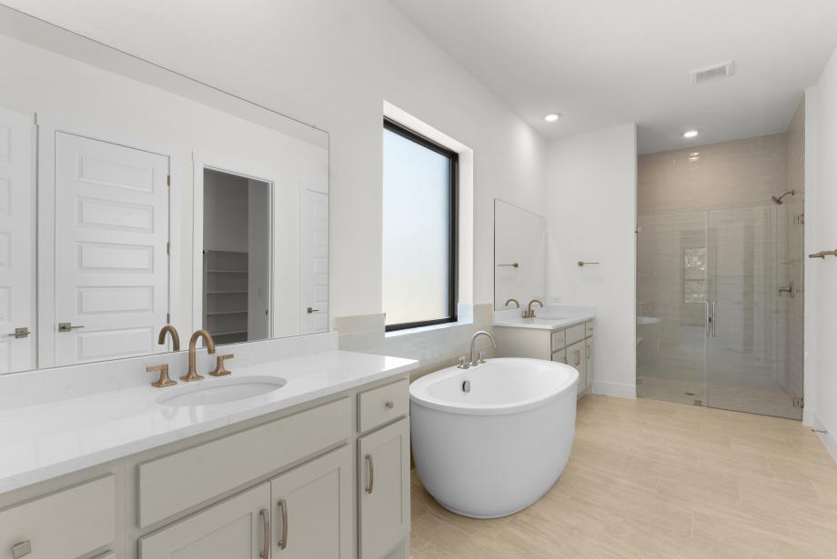 Primary bathroom suite with a dual vanities, freestanding tub, and walk-in shower