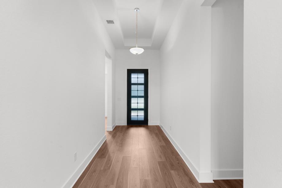 A long, elegant foyer with tray ceilings welcomes you into the home