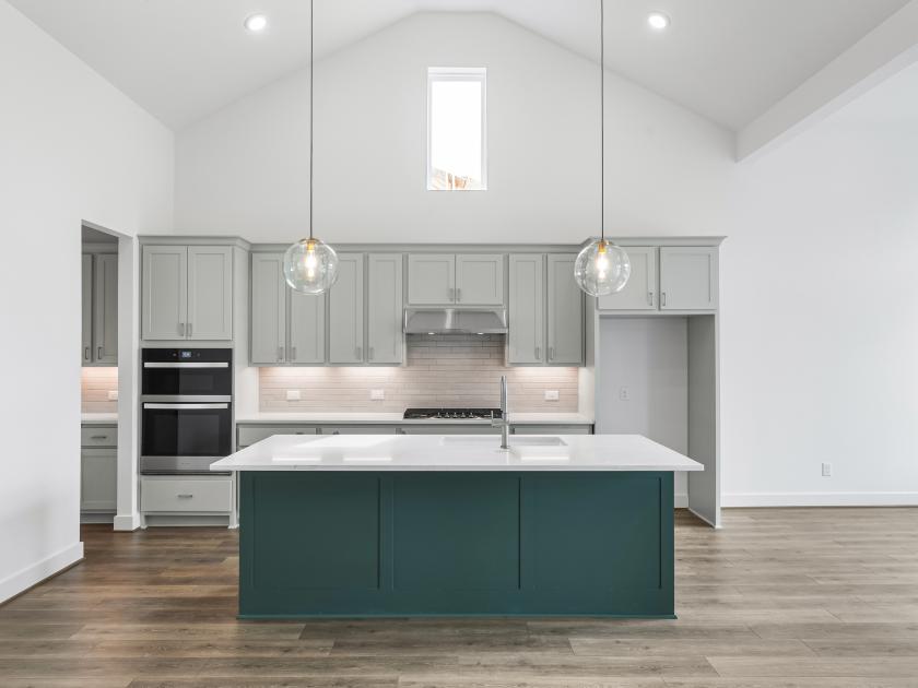 Gourmet kitchen with pendant lighting, stainless steel appliances, and center island