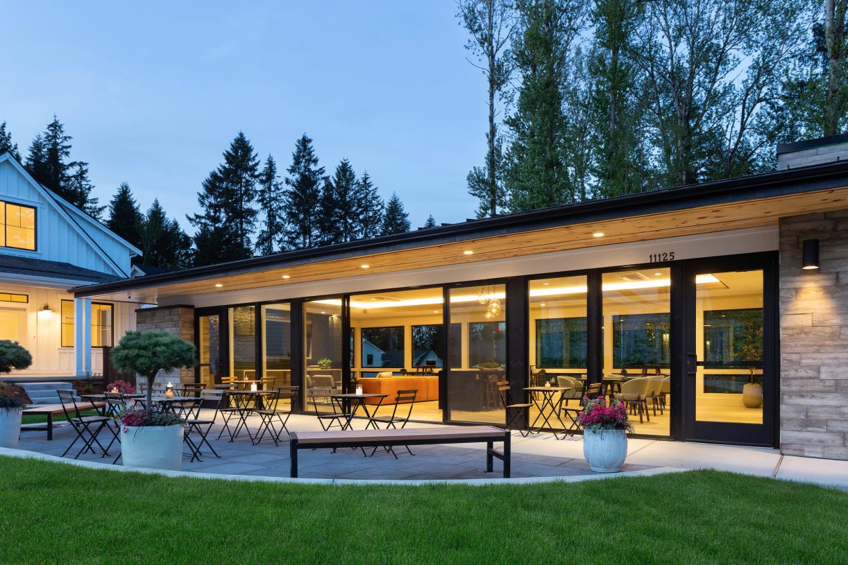 The contemporary clubhouse features floor-to-ceiling expansive glass windows looking into the green spaces