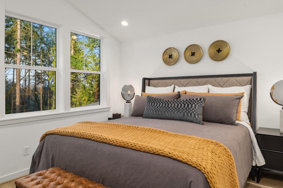 Primary bedroom with a vaulted ceiling overlooking the green space