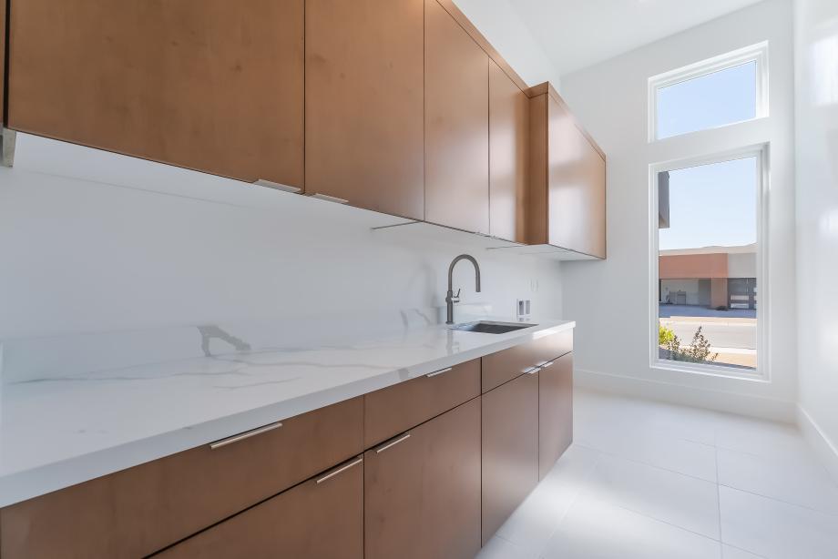 Spacious laundry with upper and lower cabinets and sink