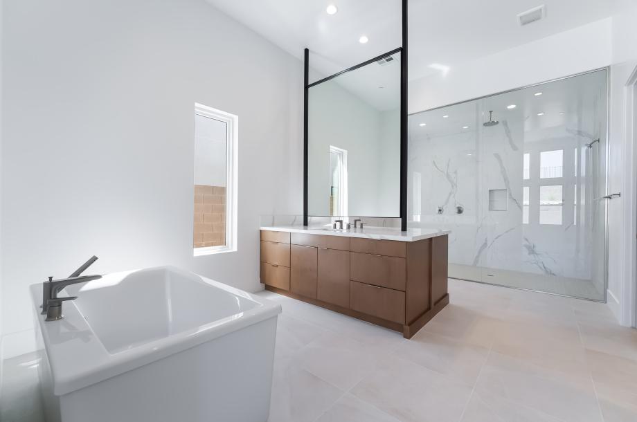 Stunning primary bath with double-sided vanity counter and slab wall shower surround