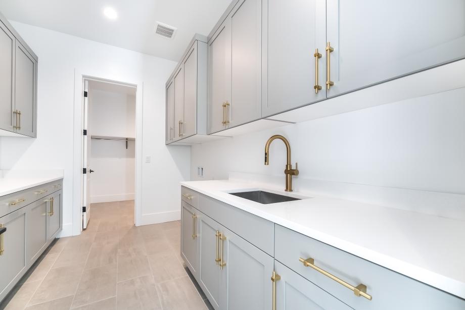 Impressive laundry room with sink and lower and upper cabinets