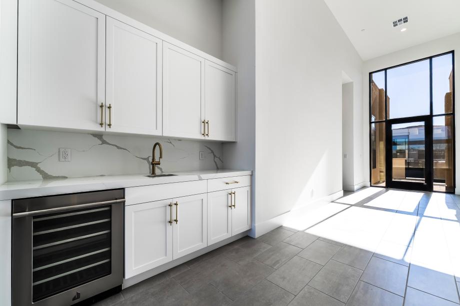 Wet bar with sink and upper cabinets at great room