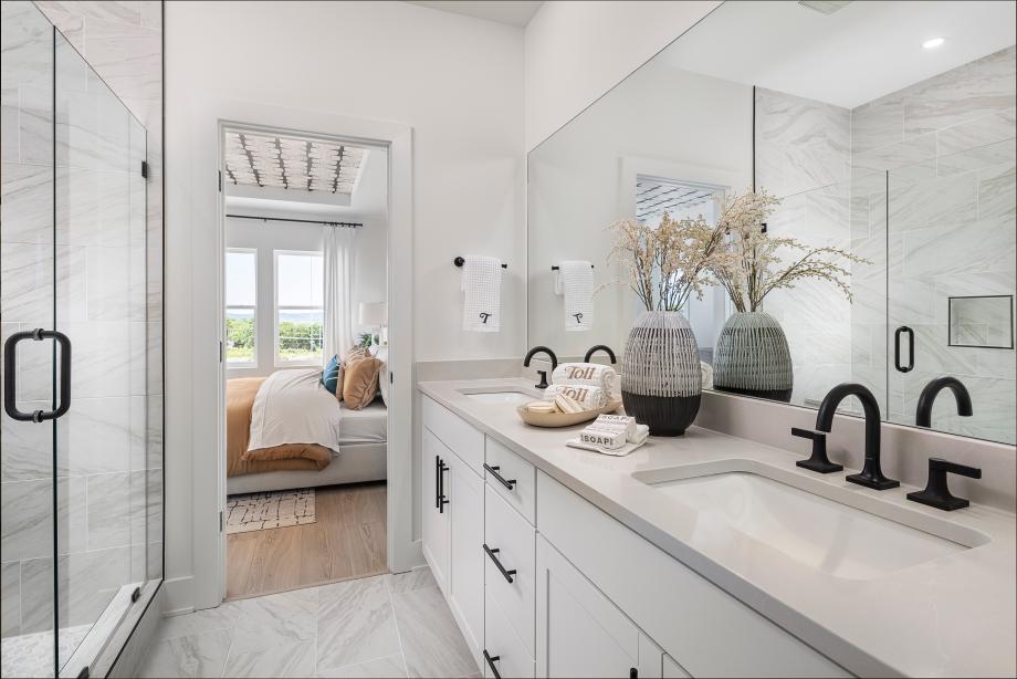 Spa-like primary bath boasts a dual-sink vanity and large glass shower