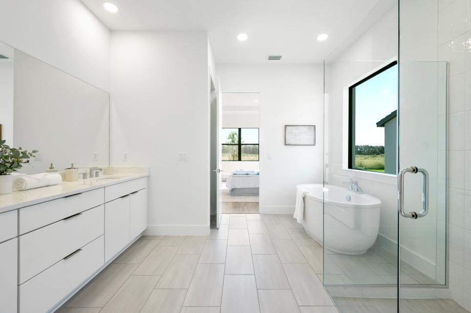 Spa-like primary bathroom featuring a freestanding soaking tub and dual-sink vanity