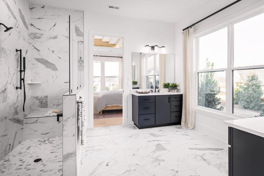 Spa-like primary bath featuring a zero-threshold shower and dual vanities
