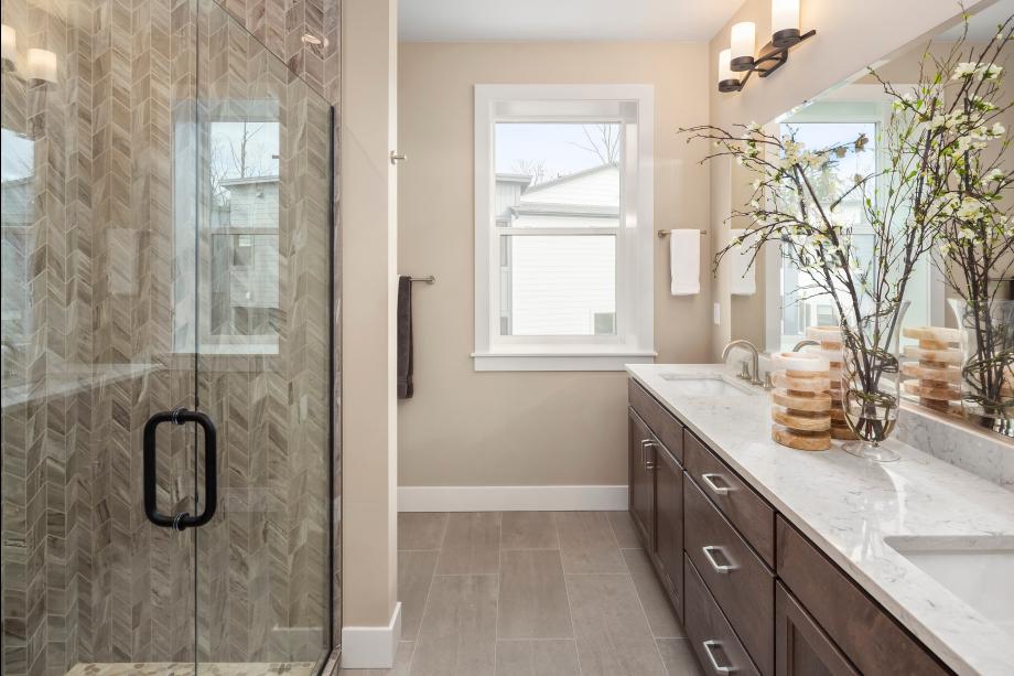 Primary bathroom features a dual-sink vanity with quartz countertop and a walk-in shower