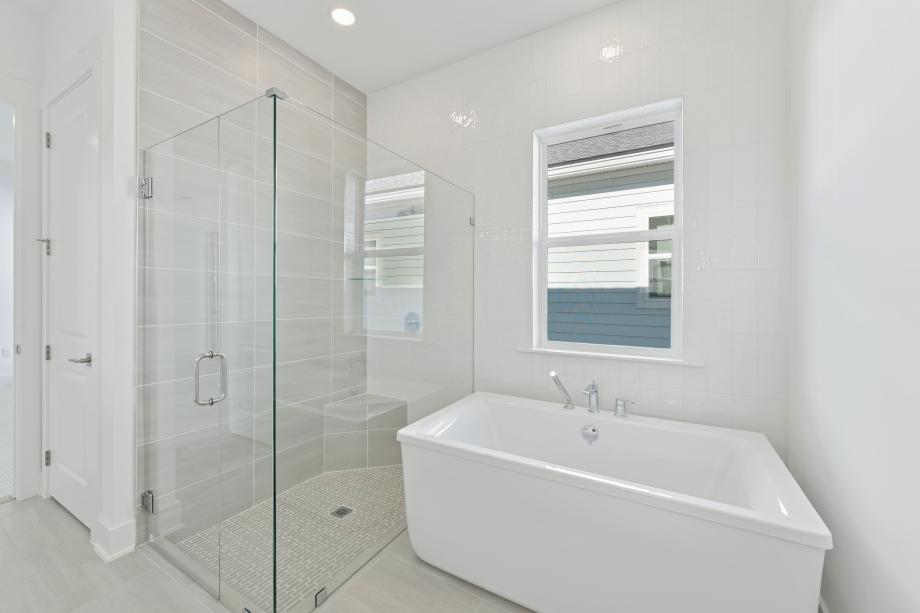 Beautiful walk-in shower and freestanding soaking tub in primary bathroom