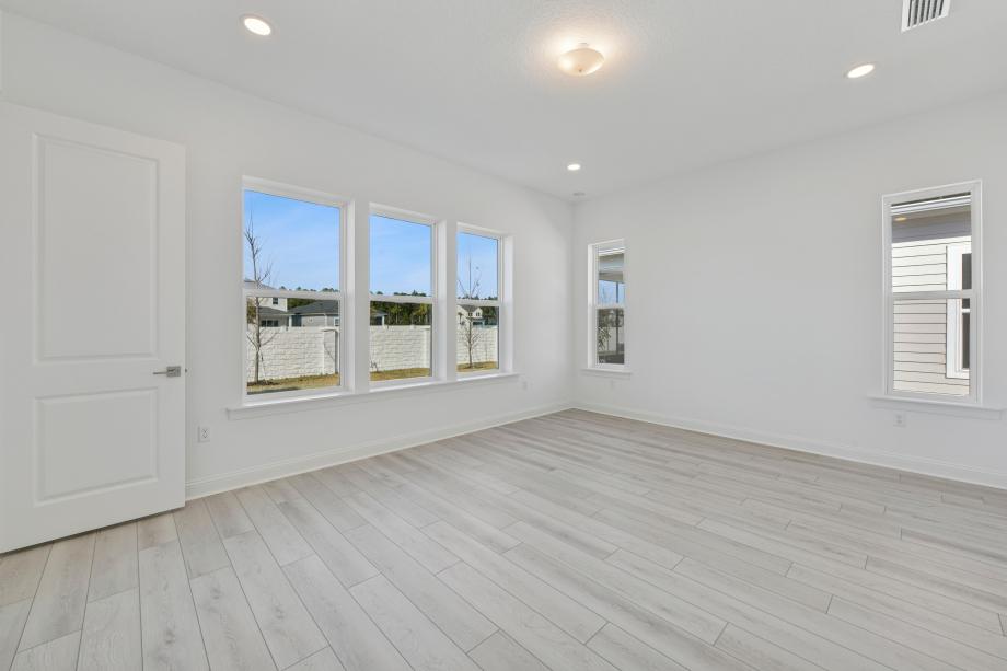 Large primary bedroom suite with a seating area and ample light