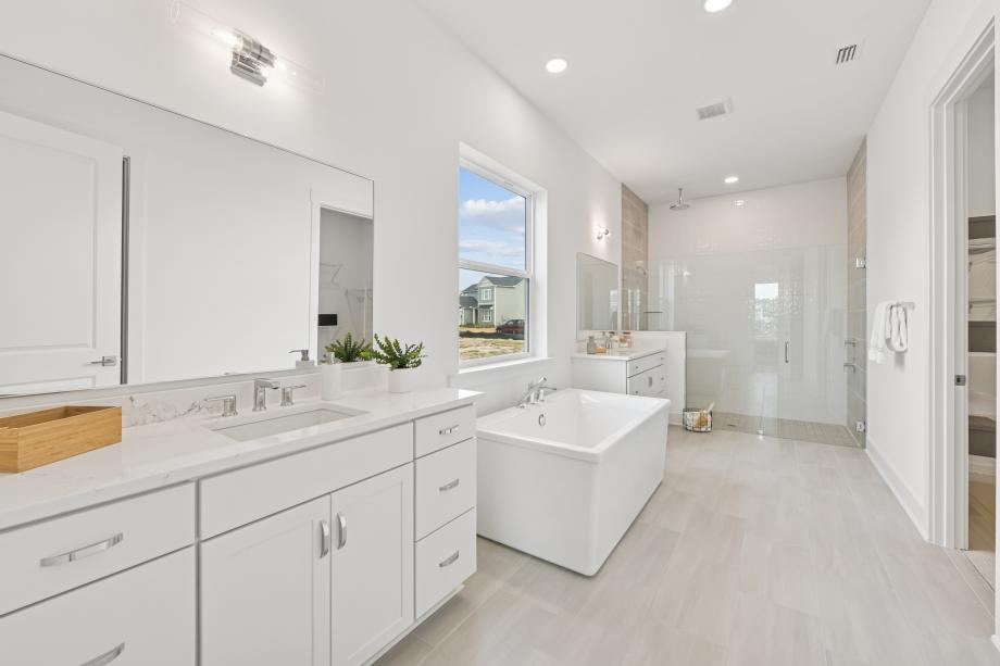 Spa-like primary bathroom with a huge walk-in shower and freestanding soaking tub